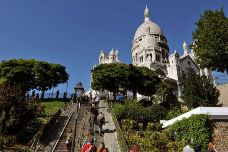 People going up the stairs to the top of the Sacre coeur, which features a magnificent broad view of Paris.