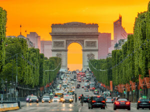 France. Paris. Dense traffic on the Champs Elysees. Triumphal Arch. Golden sunset