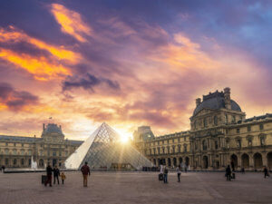 View of famous Louvre Museum with Louvre Pyramid at evening. Louvre Museum is one of the largest and most visited museums worldwide.
