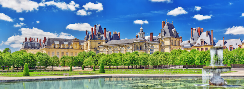 Suburban Residence of the France Kings - beautiful Chateau Fontainebleau with the fountain on foreground.